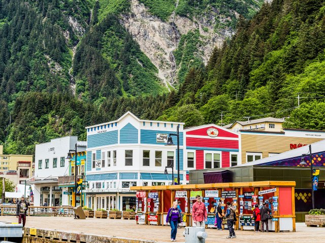 People strolling in downtown Juneau, Alaska, with mountains in backgorund