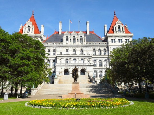 Statue and gardens in front of New York state capitol building in Albany