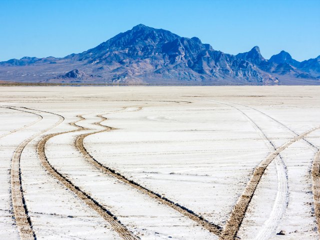 Tire tracks through desert and mountain landscape in Utah