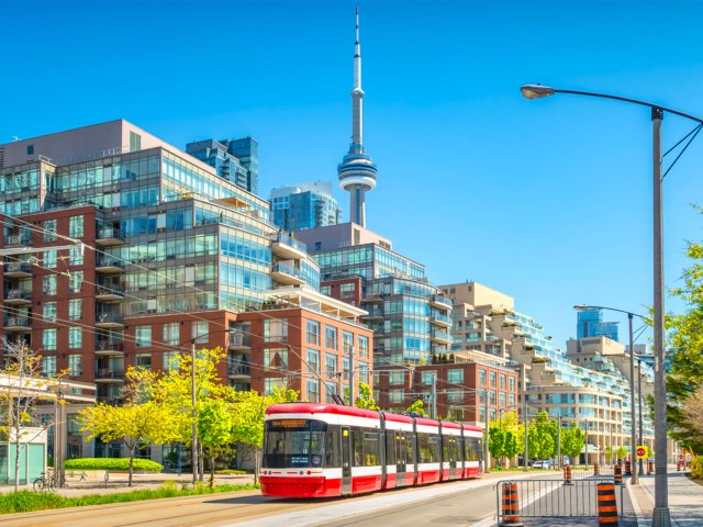 Red-and-white streetcar with Toronto skyline and CN Tower in background