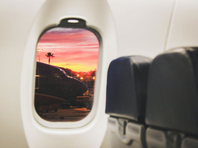 View from inside airplane cabin of another airplane outside the window