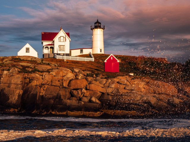 Lighthouse and home on cliff along coast of Maine