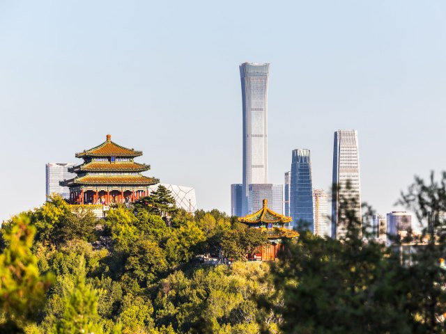 View of hilltop temple and modern Beijing skyline in the distance