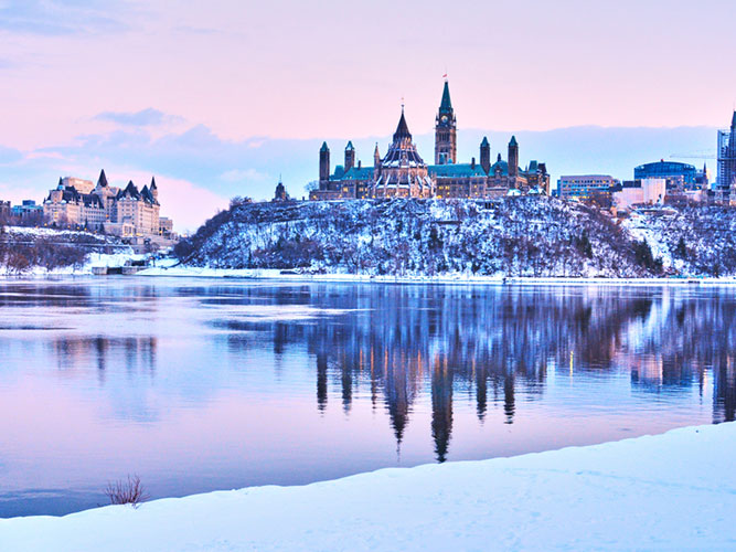 A picture of the snow-covered city of Ottawa across a frozen lake