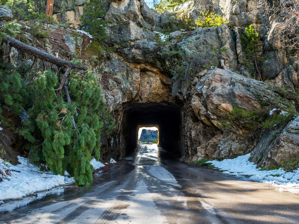 Road tunnel built through rock in the Black Hills of South Dakota