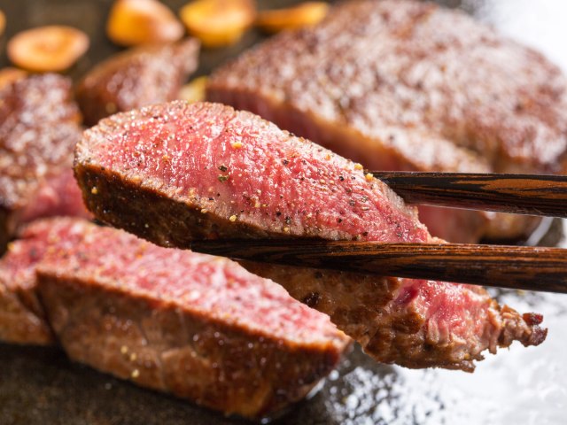 Close-up shot of chopsticks holding beef