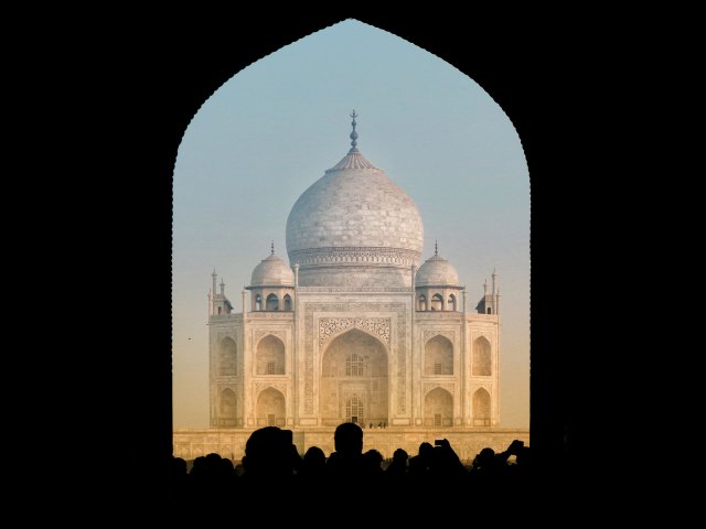 A distant picture of the Taj Mahal surrounded by black shadow