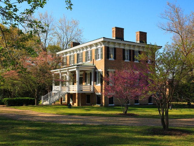 A stately red-brick manor with a large porch