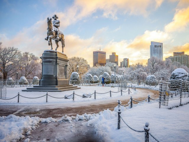 A bronze statue of Paul Revere in the middle of a snow-covered city park