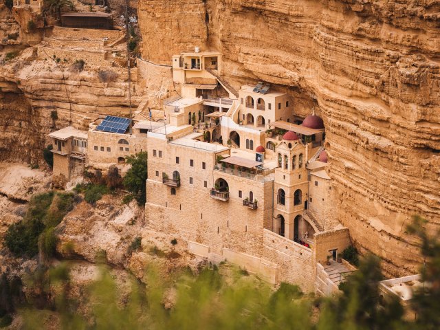 A picture of an ancient stone citadel built into a sandstone cliff