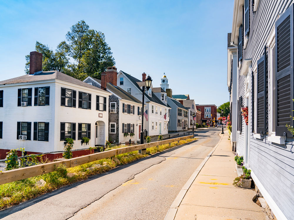 A quaint street with colonial homes flying American flags