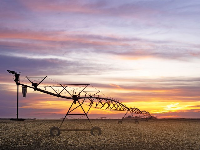 Irrigation system in Nebraska corn field at sunset