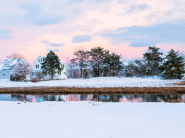 Snowy landscape with homes and river in Maine