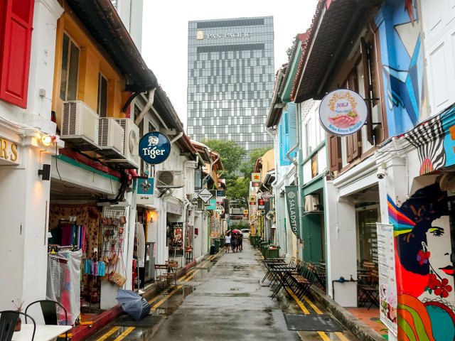 Storefronts lining narrow, empty street in Singapore