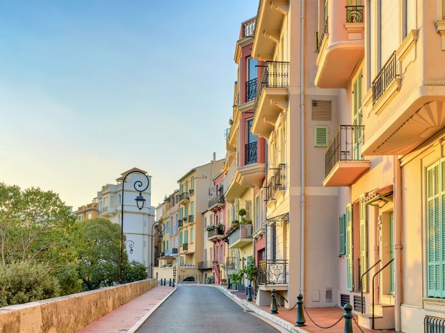Narrow street in Monaco lined with apartment buildings at sunset