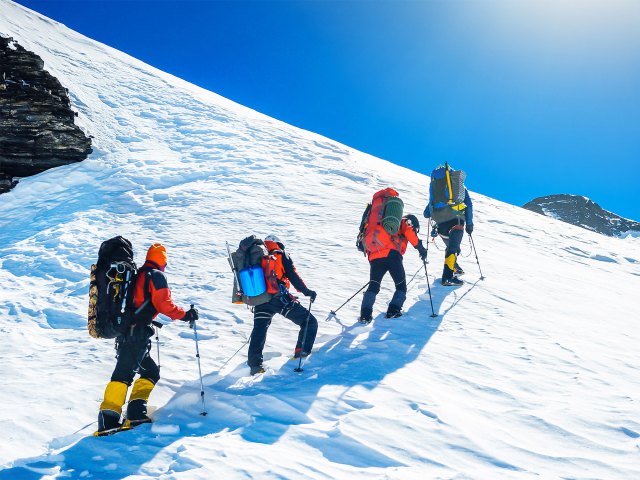 Trekkers in line hiking up snowy Mount Everest