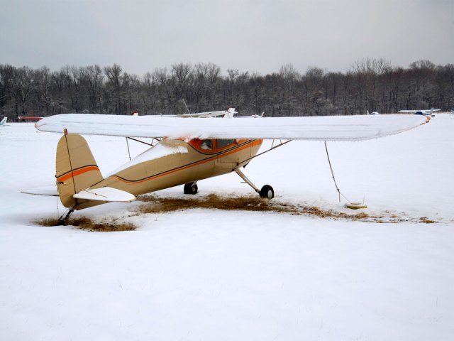 Biplane covered in snow at College Park Airport in Maryland