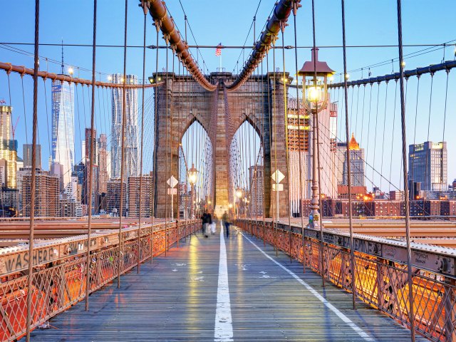 Time-lapse photo of people walking across Brooklyn Bridge in New York City