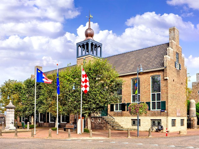 Flags flying in front of brick building in Baarle-Nassau, Netherlands