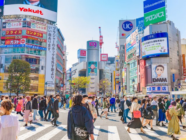 Busy street crossing filled with pedestrians and billboards in Tokyo, Japan