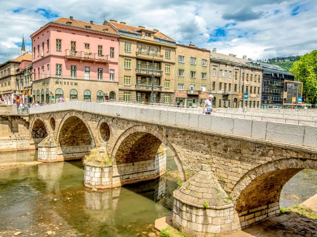 Person walking on stone bridge over canal in Bosnia and Herzegovina