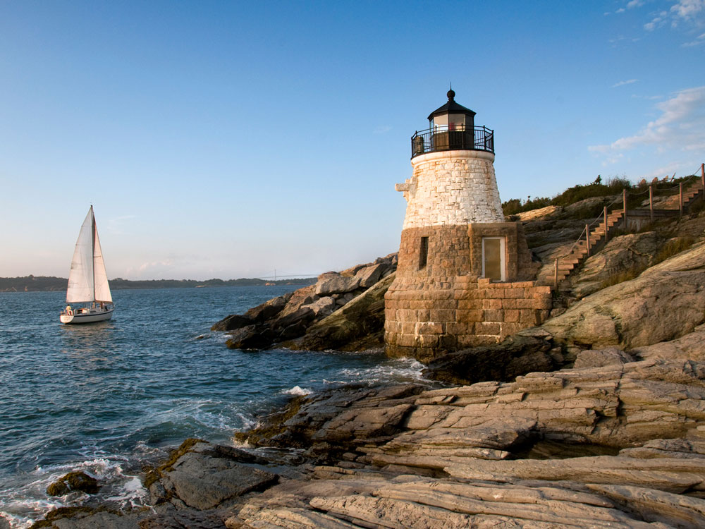 Lighthouse and sailboat on the coast of Rhode Island