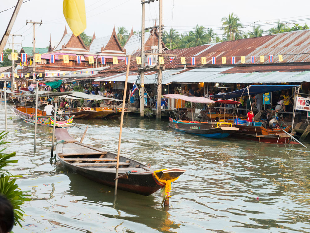 Boats and market stalls of Amphawa Floating Market in Thailand