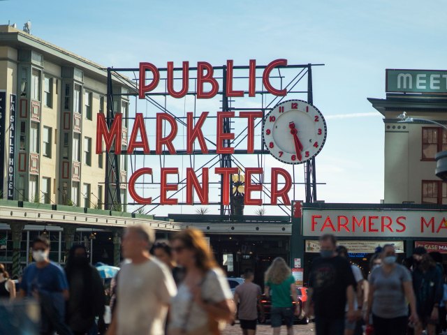 People walking under sign for Pike Place Market in Seattle, Washington