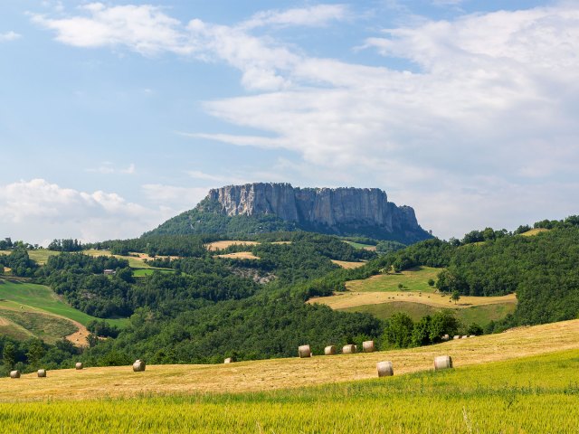 Field and rock formation in distance in Emilia Romagna, Italy
