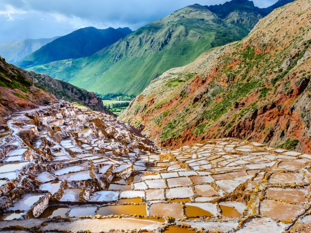 View from mountaintop of Salineras de Maras in Peru wedged between mountains