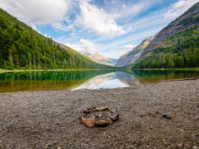 Glacial lake in Montana surrounded by mountains and forest