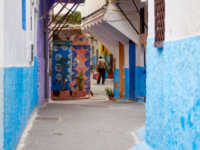 Narrow alleyway flanked by blue walls in Morocco