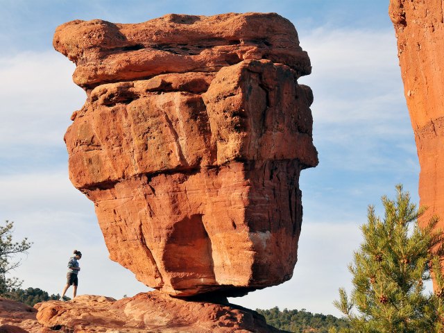 Hiker next to Balanced Rock in Colorado