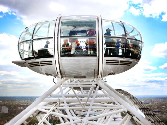Close-up of riders on the London Eye Ferris wheel above the London, England, skyline