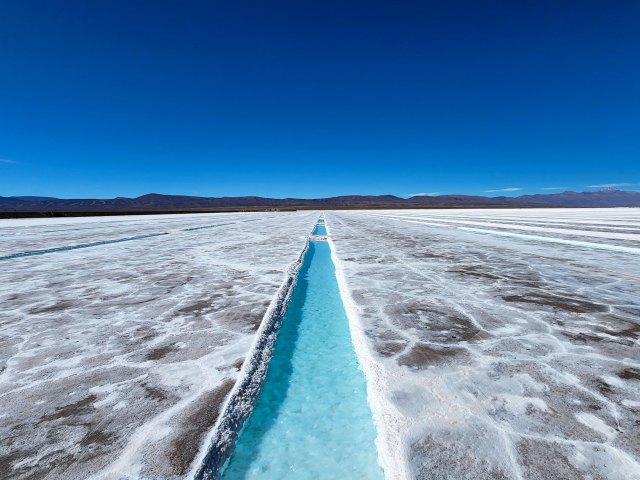 Turquoise water channel running through Salinas Grandes salt flat in Argentina