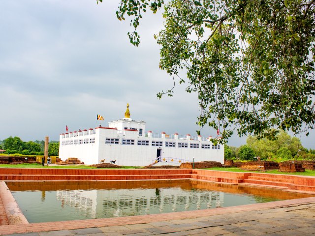 White temple and reflective pool in Lumbini, Nepal