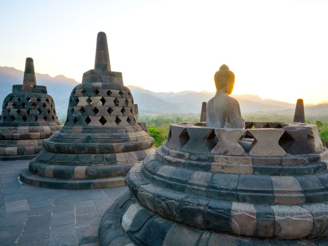 Buddha statue overlooking countryside at Borobudur Temple in Indonesia