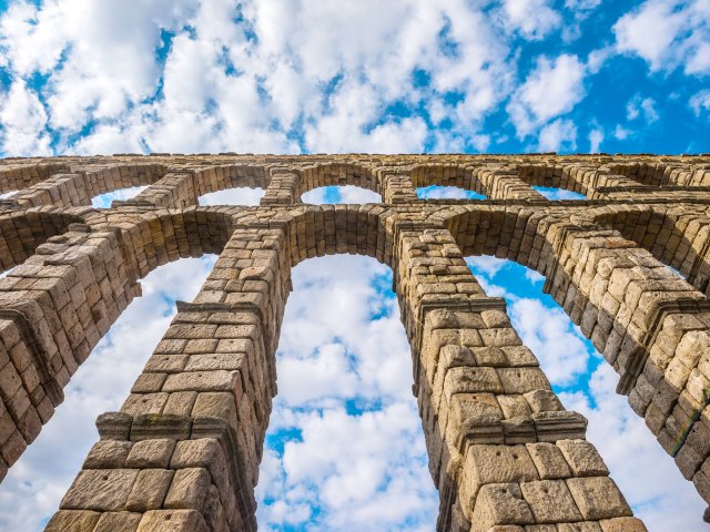 View up at stone structure of Aqueduct of Segovia in Spain