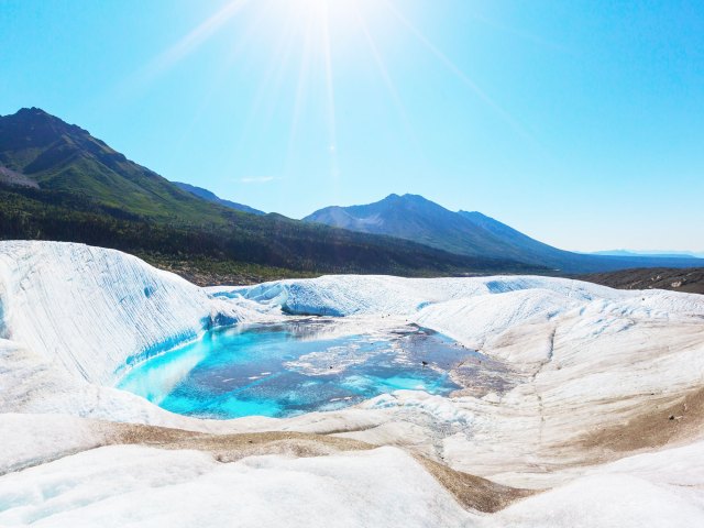 Glacial pool with mountains in background in Wrangell-St. Elias National Park and Preserve