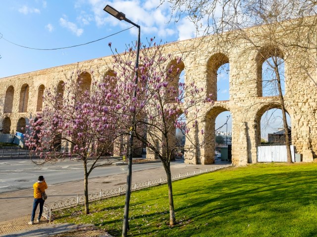 Person taking a photograph of Aqueduct of Valens in Istanbul, Turkey
