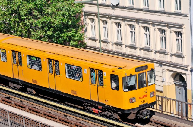 Yellow subway train on elevated tracks in Berlin, Germany