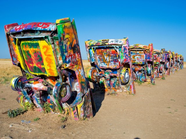 Grafitti-covered cars half-buried in desert at Cadillac Ranch in Texas