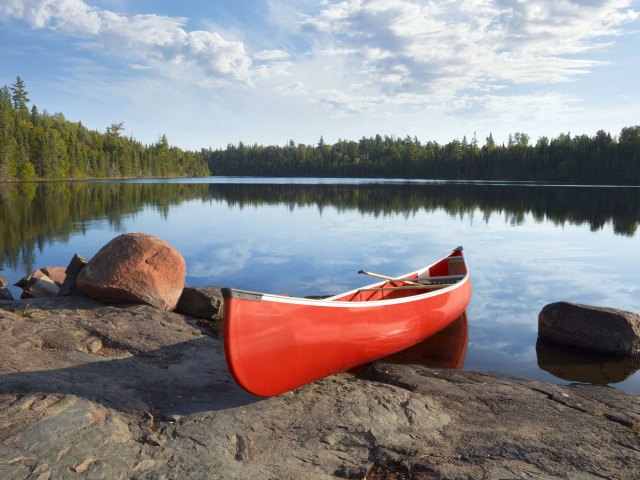 Red canoe docked on rocks in Boundary Waters Canoe Area Wilderness in Minnesota