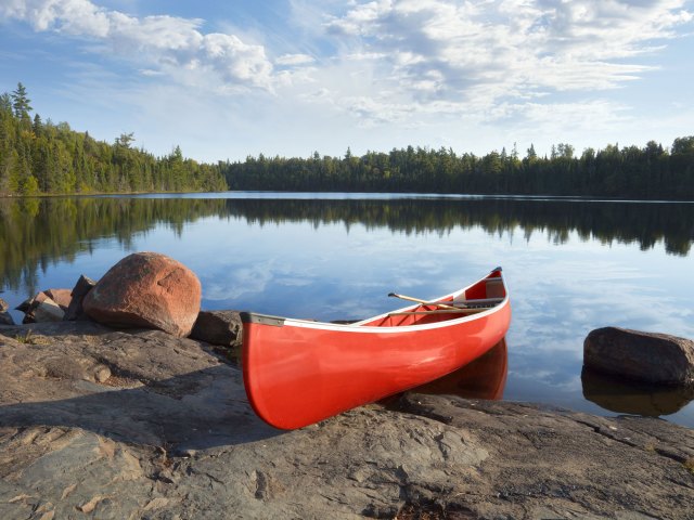 Red canoe docked on rocks in Boundary Waters Canoe Area Wilderness in Minnesota
