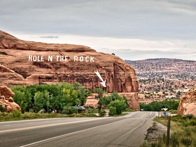 Sign painted on mountain indicating Hole in the Rock roadside attraction in Utah