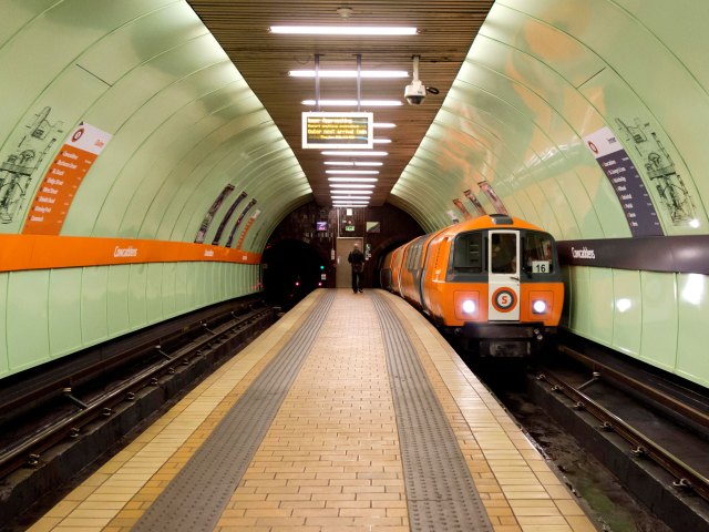 Orange subway train entering station in Glasgow, Scotland