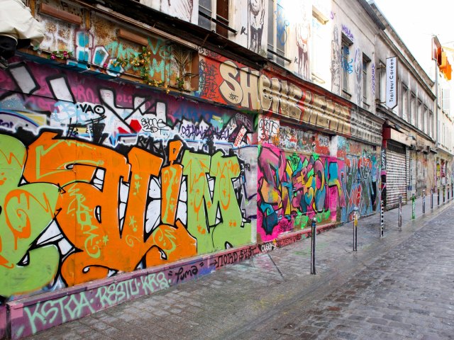 Graffiti-covered buildings on Rue Dénoyez in Paris, France