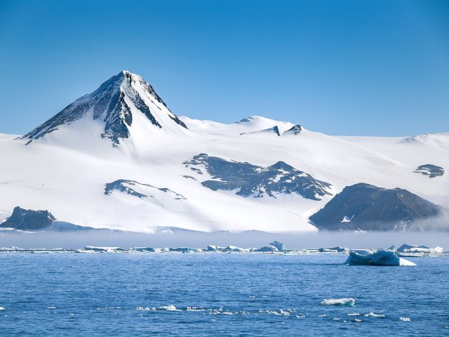 Snow-covered Mount Vinson in Antarctica, seen from across lake