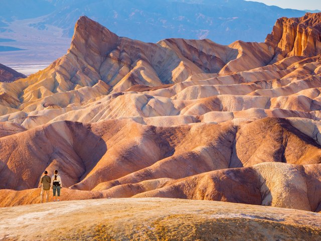 People overlooking undulating desert landscape of Death Valley National Park in California 