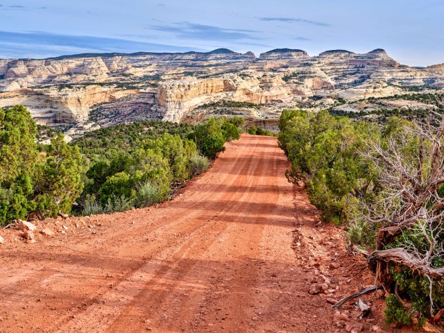 Empty dirt road leading to striated rocks in Dinosaur National Monument in Colorado